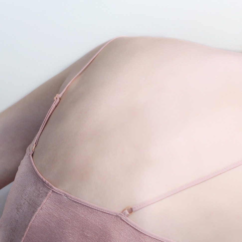 Close-up of skin and a pink silk strap