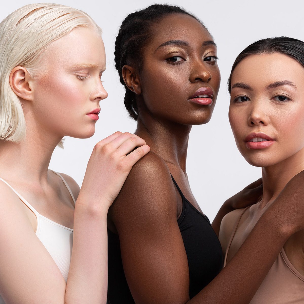 Three women standing close together, looking straight at the camera
